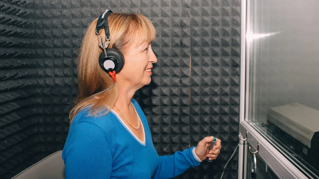 Patient receiving a hearing evaluation in a sound-treated booth
